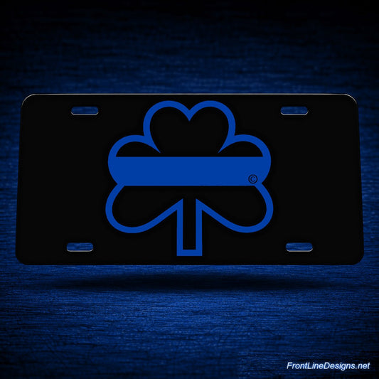 Blue Line Reflective Shamrock License Plate — floating presentation on blue textured backdrop
