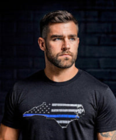 Man wearing a black t-shirt with a NC Blue Line design.